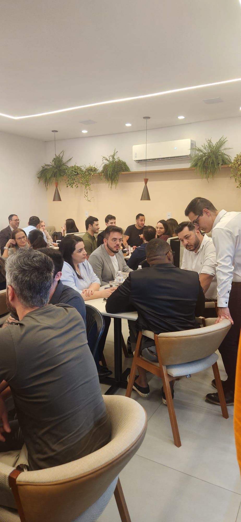 Participantes reunidos em mesas durante o evento de networking